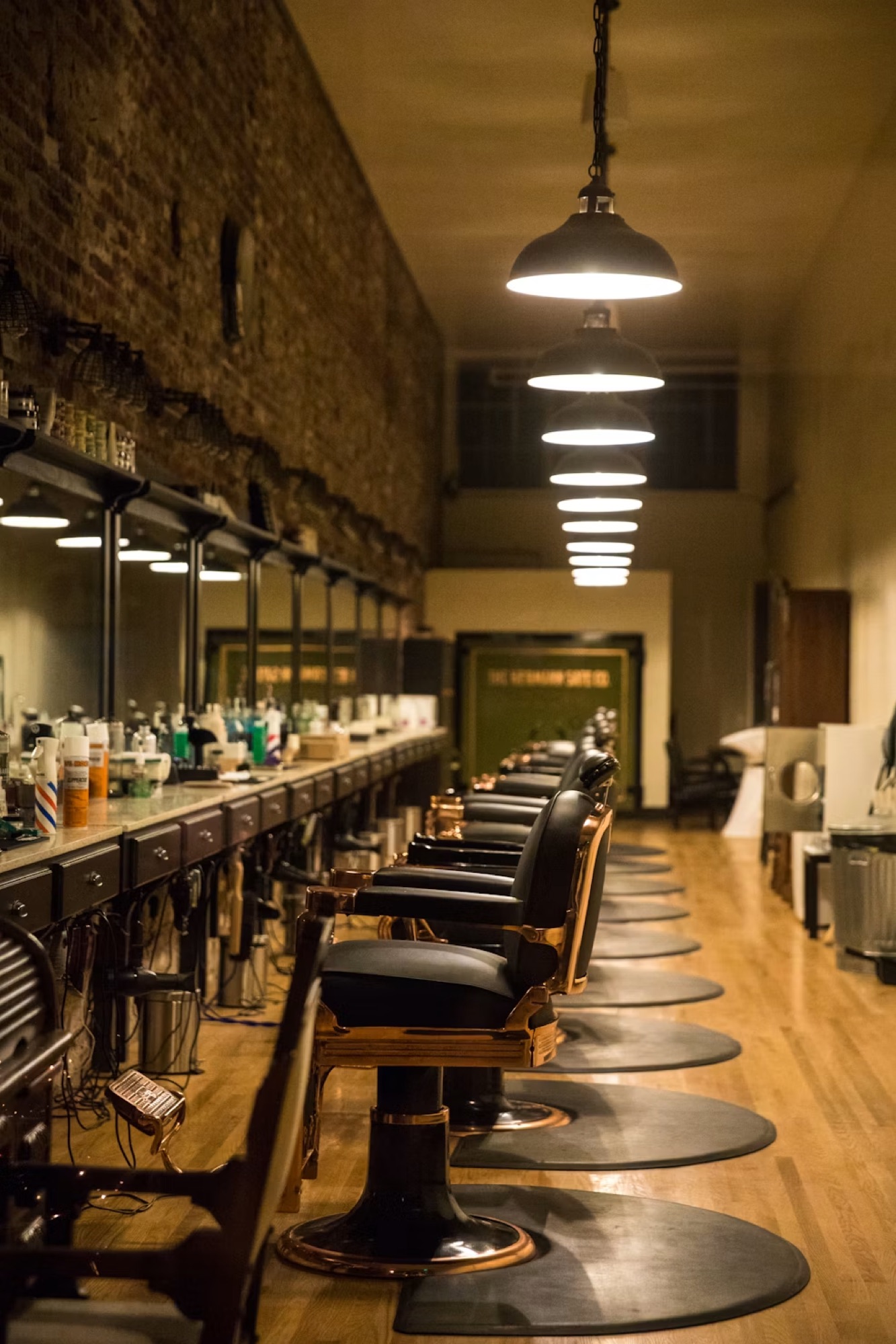 A row of barber chairs along a mirrored station wall